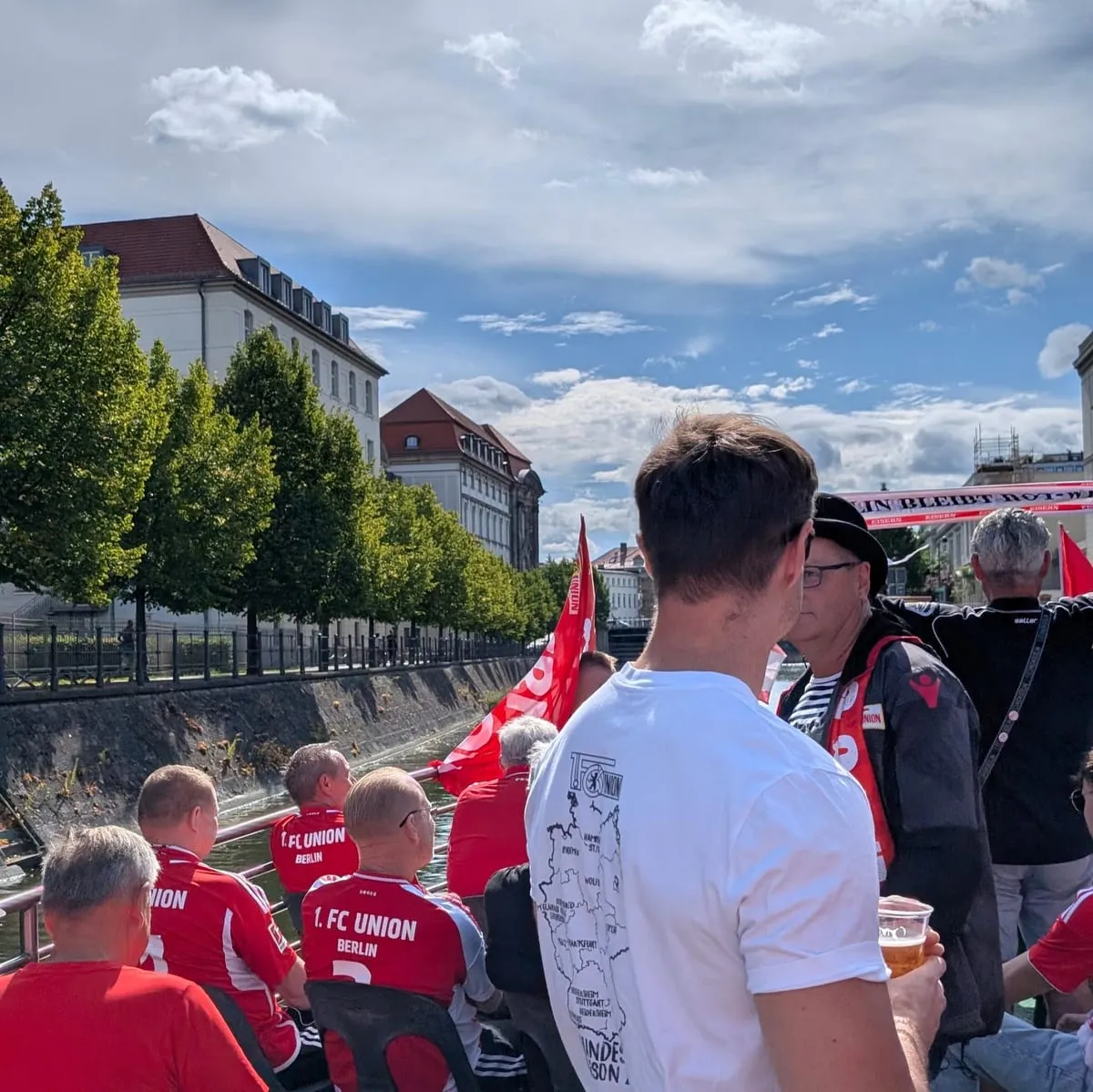Union fans in red shirts packed onto the deck of the matchday boat on the Spree, club flags flying and a "Berlin bleibt rot-weiss" banner along the rail